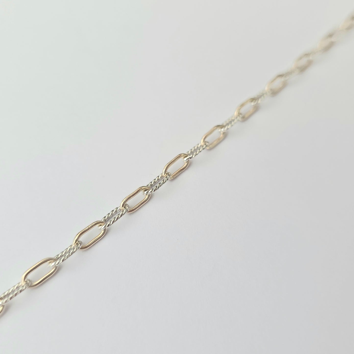 Silver chain necklace on a light gray background