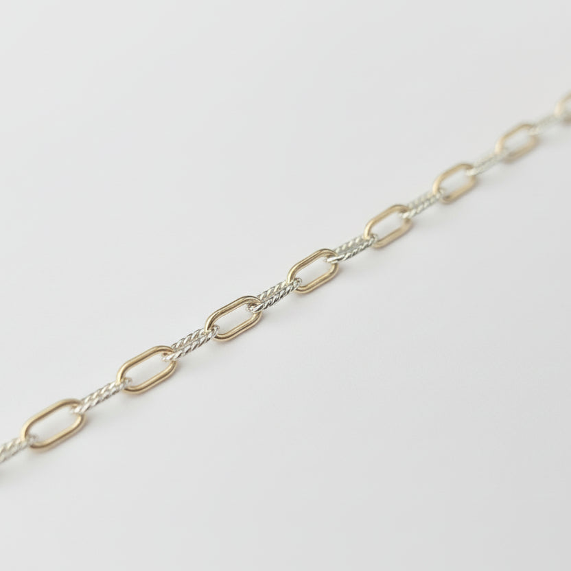 Silver chain necklace on a light gray background