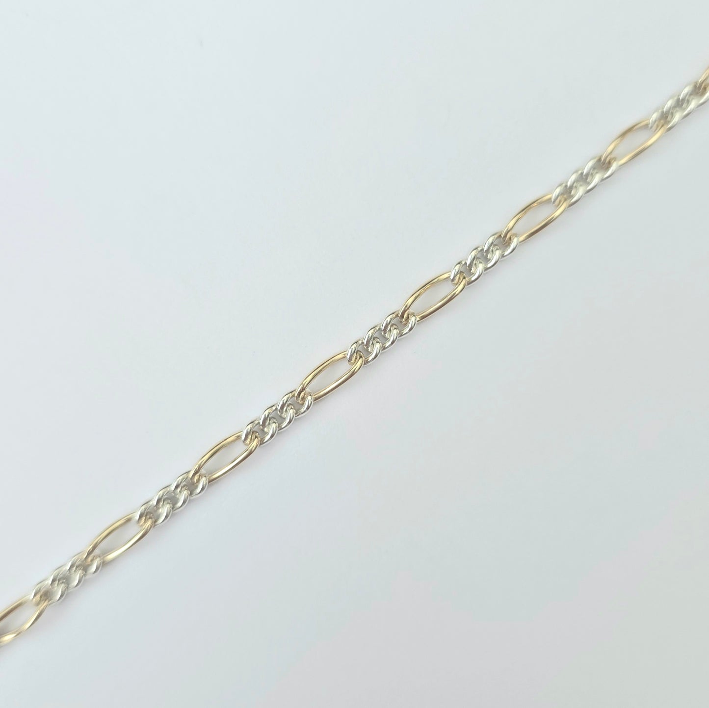 Gold and silver chain on a light gray background