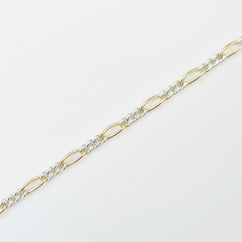 Gold and silver chain on a light gray background
