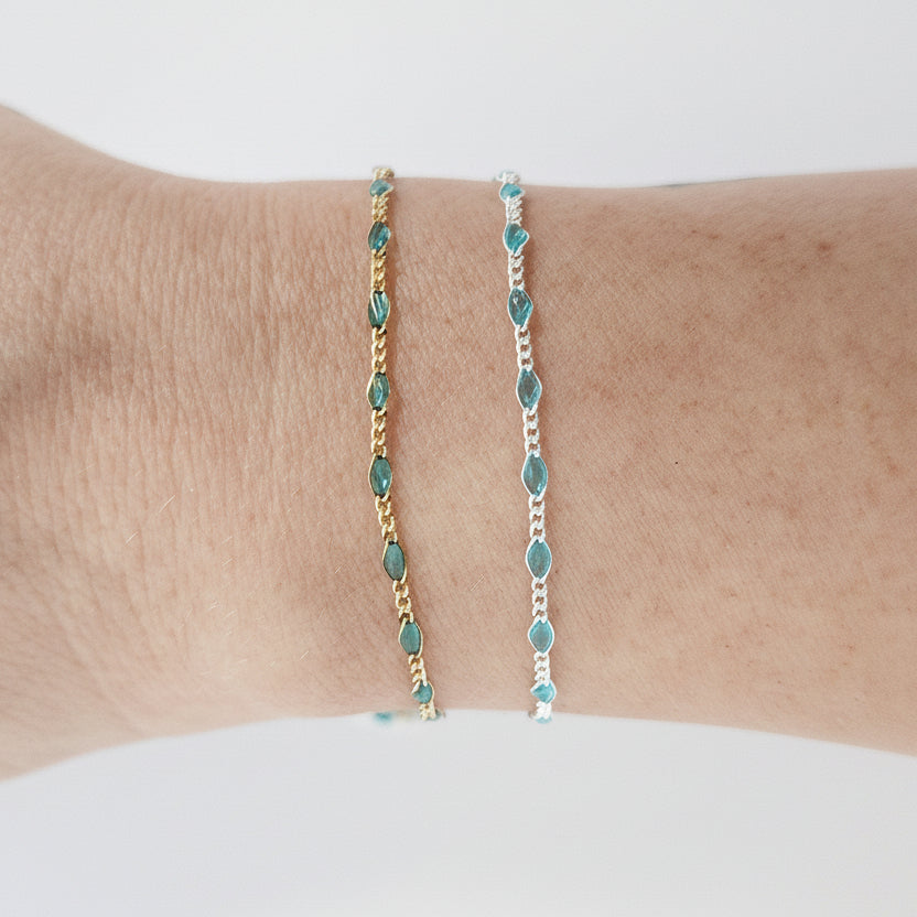 Two turquoise beaded bracelets on a wrist against a white background