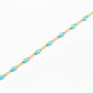 Gold chain with turquoise beads on a light gray background