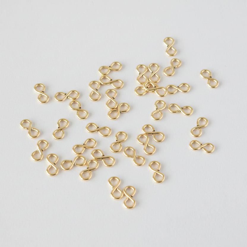 Gold infinity-shaped connectors on a light gray background