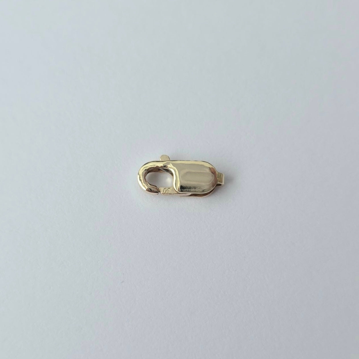 Gold clasp on a light gray background