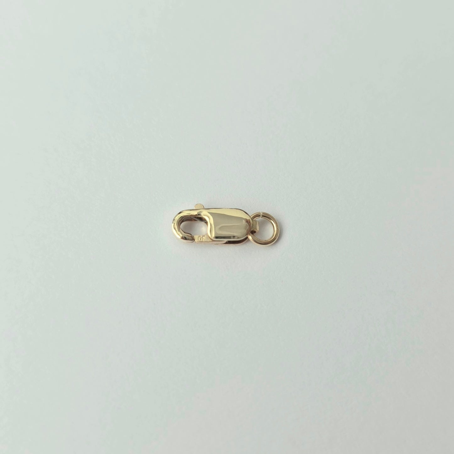 Gold clasp on a light gray background