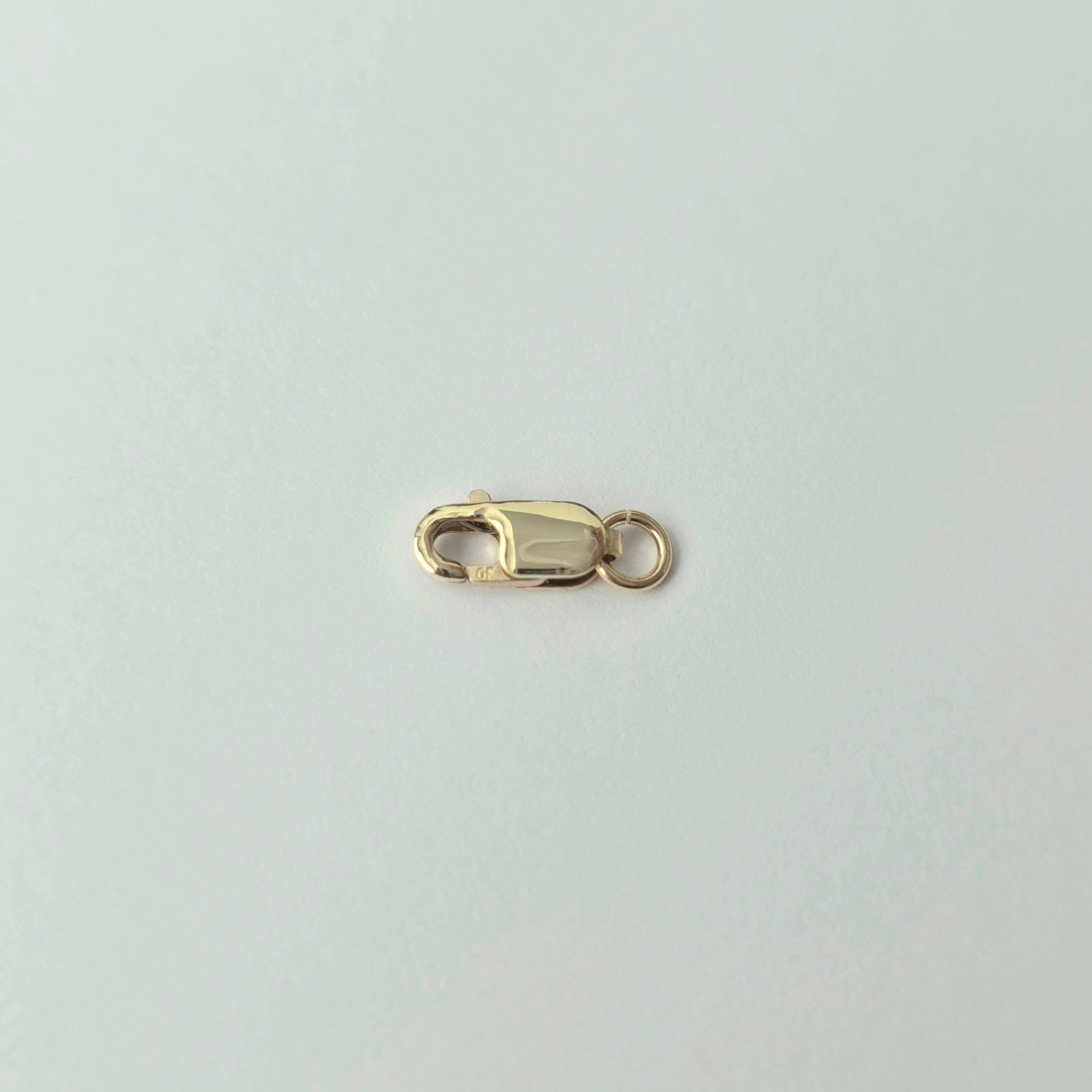 Gold clasp on a light gray background