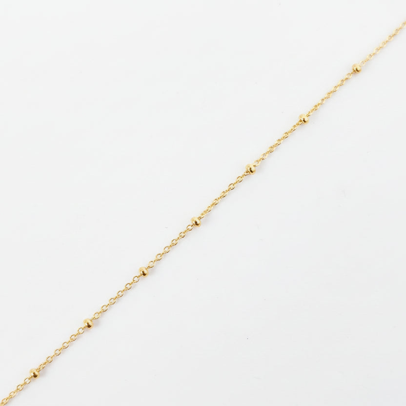 Gold chain on a light gray background
