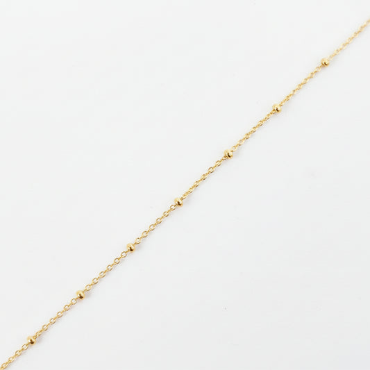Gold chain on a light gray background