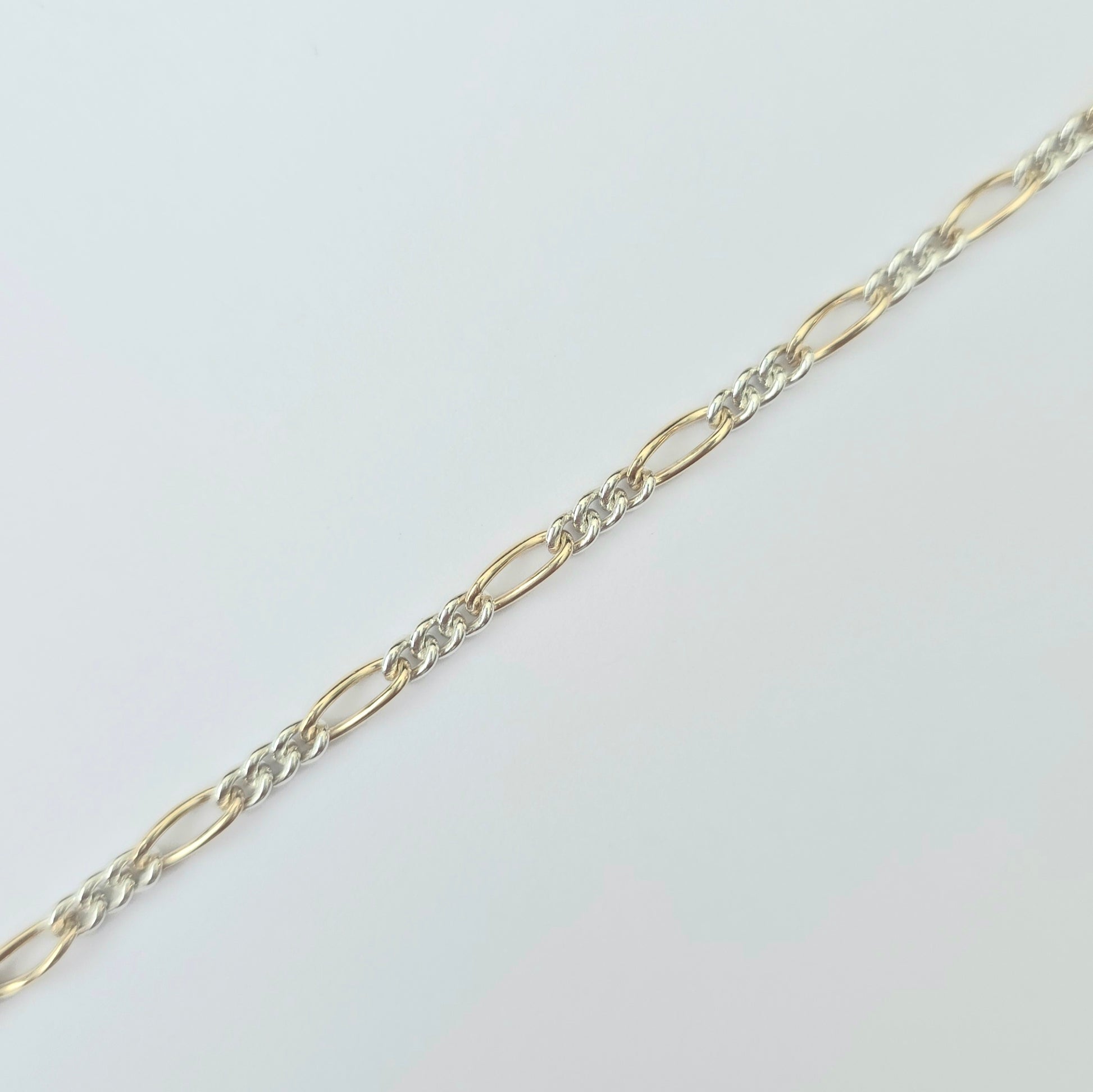 Gold and silver chain on a light gray background