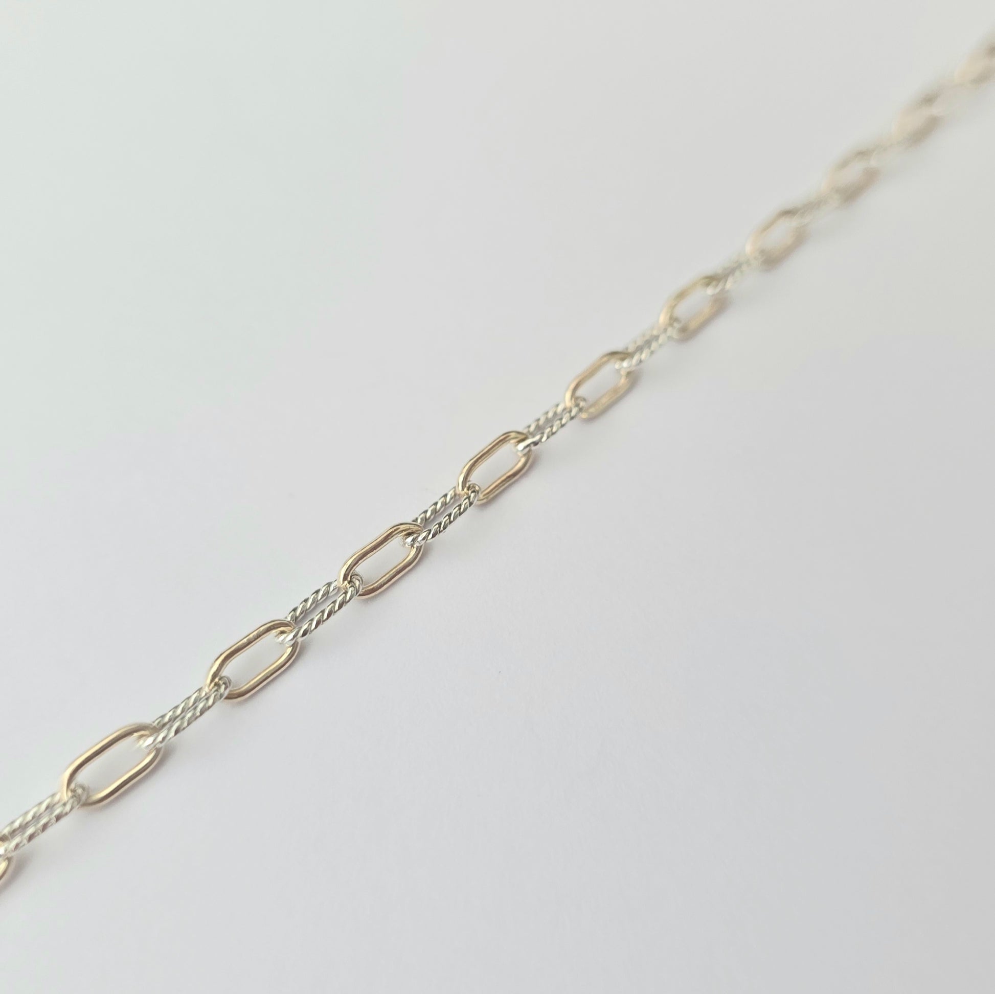 Silver chain necklace on a light gray background