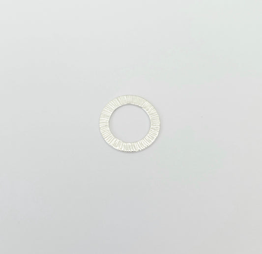 Silver ring with a textured band on a light gray background
