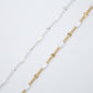 Two gold and silver bracelets with beaded design on a light gray background