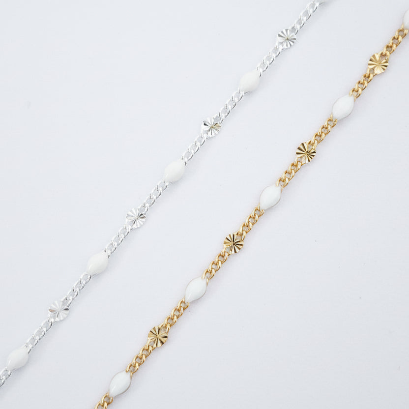 Two gold and silver bracelets with beaded design on a light gray background