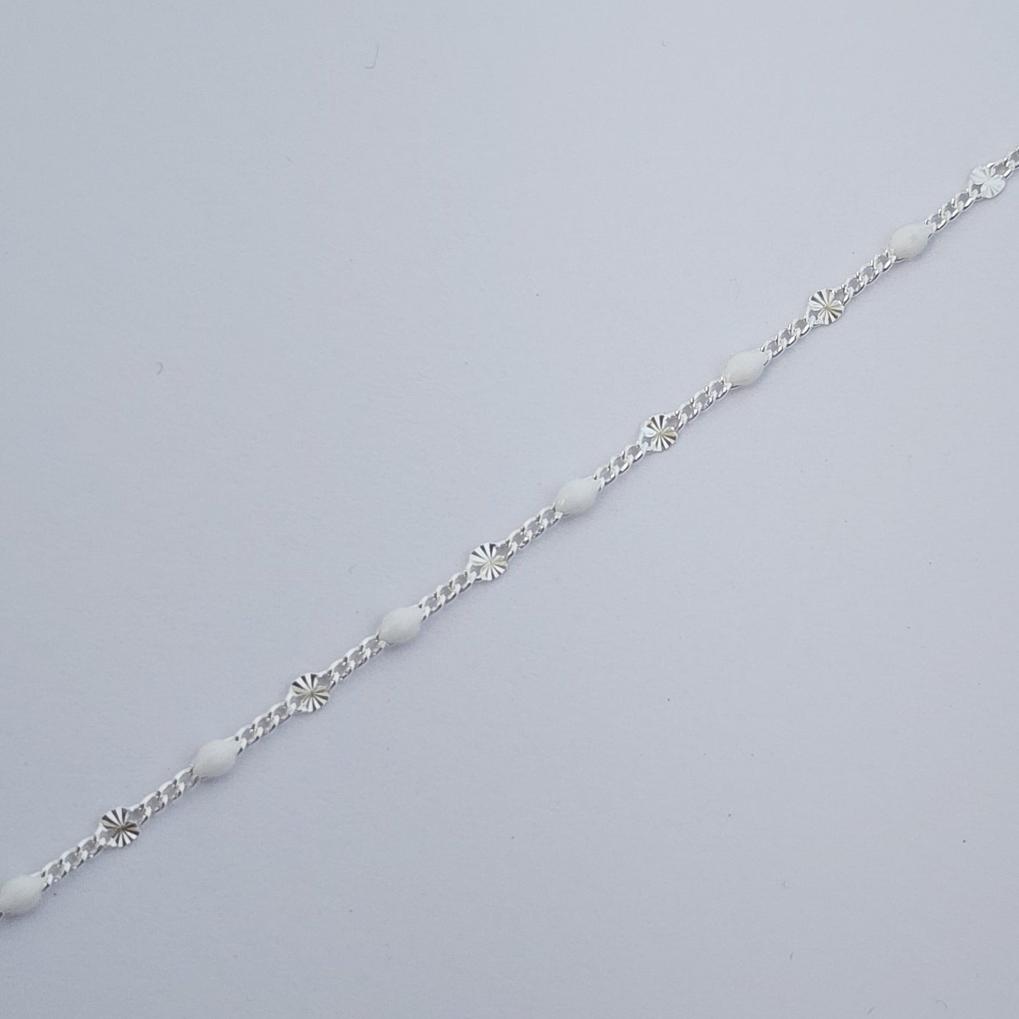 Silver bracelet on a light gray background